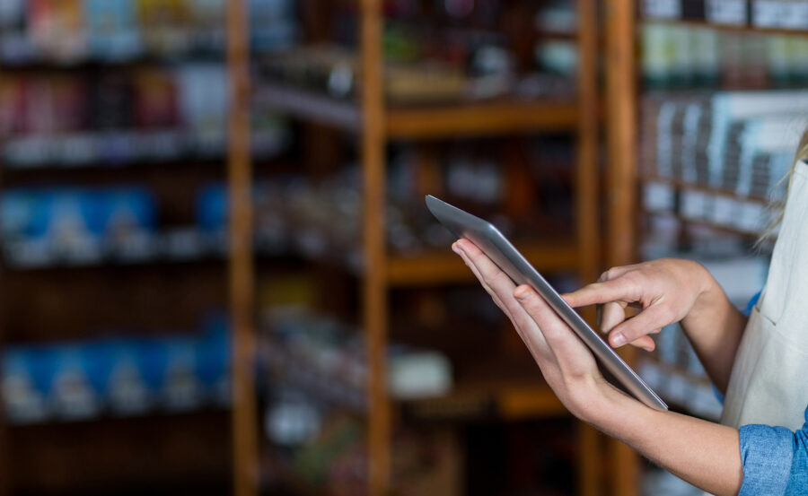 Female staff using digital tablet in supermarket