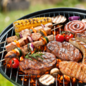 Meat and vegetables on an outdoor grill.