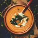 Savory bowl of squash soup garnished and presented on burlap.