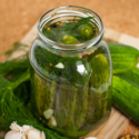 Image of a jar of cucumbers being prepared to be pickled.