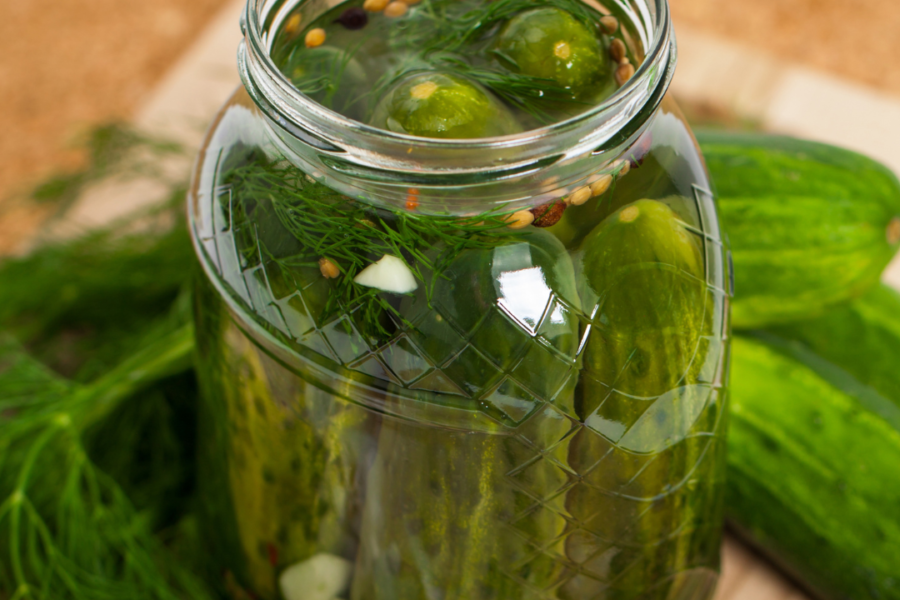 Image of a jar of cucumbers being prepared to be pickled.