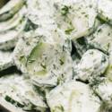 Close-up image of Cucumber Salad lathered in creamy dressing.